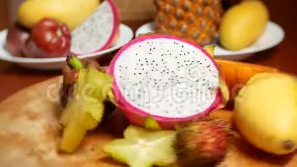 餐桌上的异国水果采购产品4k杨桃和龙果木瓜芒果芒果和龙眼西番莲水果视频的预览图