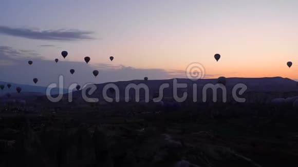 许多热气球飞过土耳其戈尔梅的山谷来自世界各地的游客来到视频的预览图