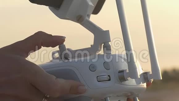 女性手在沙质海岸操纵无人机的控制通道视频的预览图