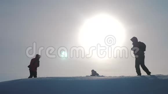 团队合作团队旅游徒步旅行者成功赢冬到达山顶剪影阳光游客视频的预览图