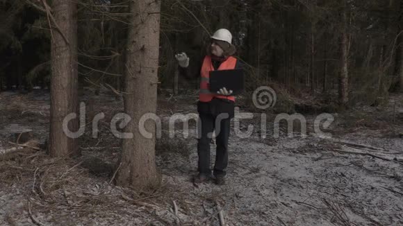 疲惫的伐木工人带着笔记本电脑在森林里视频的预览图