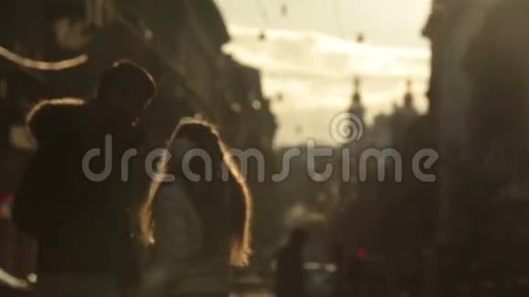 温柔的年轻夫妇在爱中轻轻拥抱日落冬天早晨欧洲城市的街道背景利沃夫视频的预览图