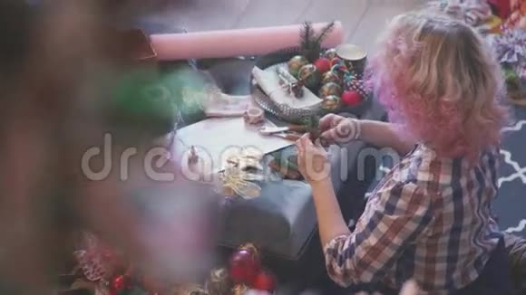 有卷曲的白色和粉红色头发的女人包装圣诞礼物视频的预览图