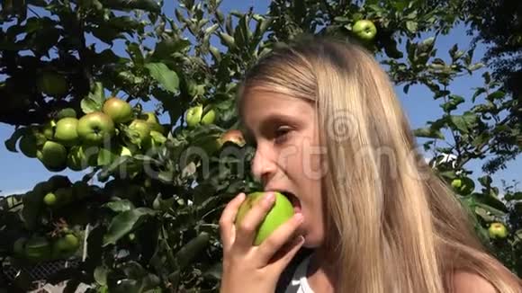 吃苹果的孩子果园里的孩子树上的水果的农民女孩视频的预览图