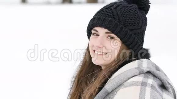 在寒冷的风天美丽的女孩对着镜头微笑的肖像慢慢地视频的预览图