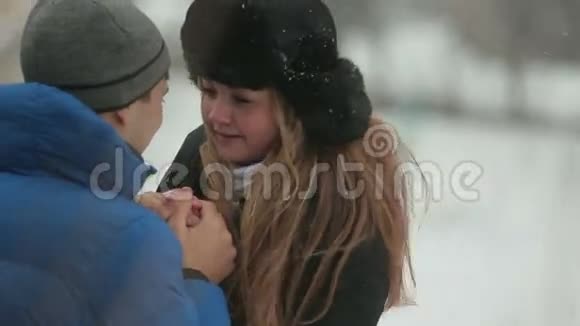 冬天森林里的年轻夫妇拥抱在一起视频的预览图