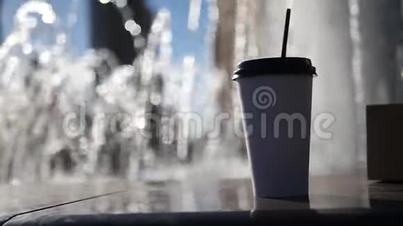 两杯咖啡和他们一起放在一个纸杯支架附近一个清爽的喷泉红色模糊的背景下面的动作高清高清视频的预览图