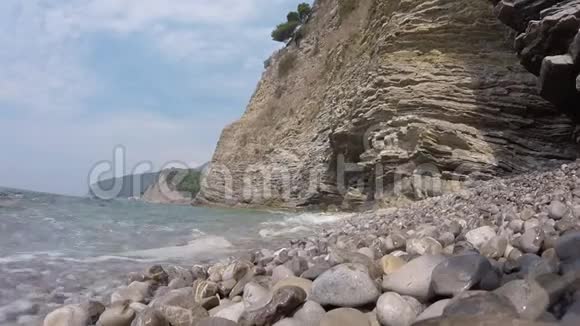 海浪拍打在卵石海滩上岩石海岸和温和海浪视频视频的预览图