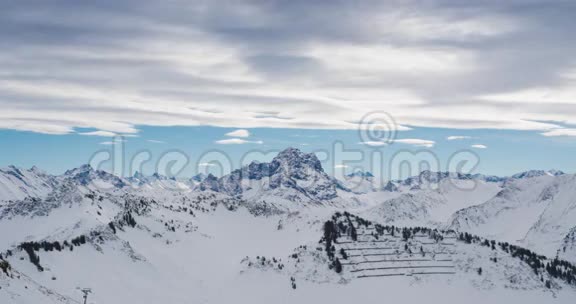 积雪覆盖的高山山脉上的云层与滑雪电梯的时间间隔视频的预览图