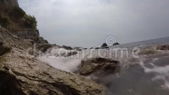 海浪拍打在卵石海滩上岩石海岸和温和海浪视频视频的预览图