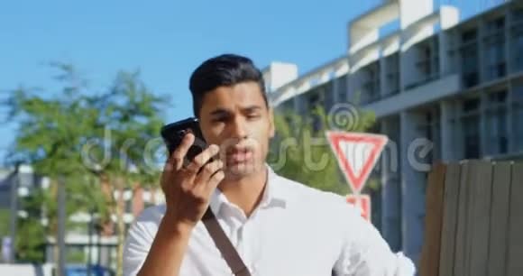男子在4k街上行走时用手机说话视频的预览图