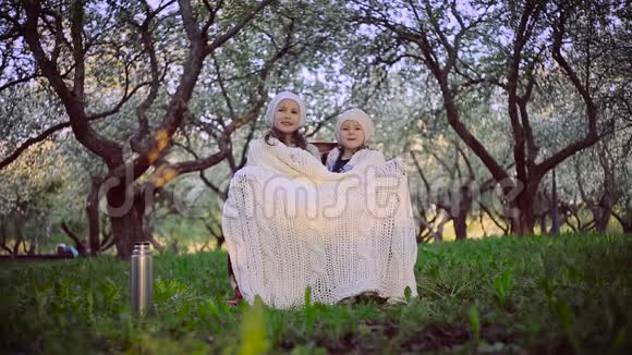 两个姐姐在公园里被一块格子布遮着视频的预览图