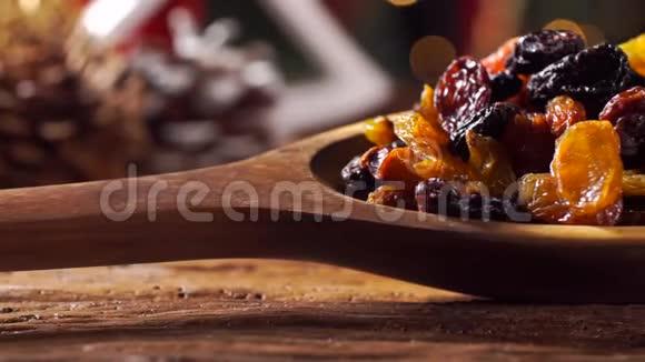 葡萄干放入一个木制勺子上的乡村老木桌与圣诞节背景视频的预览图
