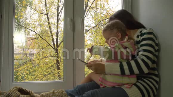 秋日母女俩在碑栏的窗台上玩耍视频的预览图
