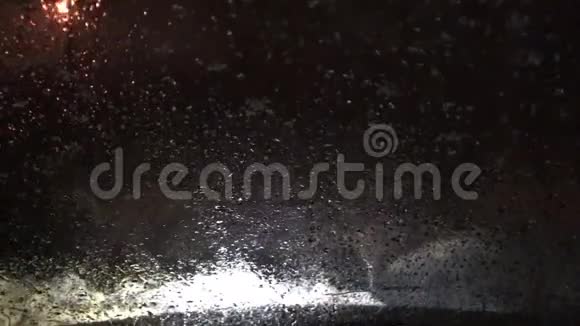 汽车雨刷在夜间清理挡风玻璃上的水滴视频的预览图