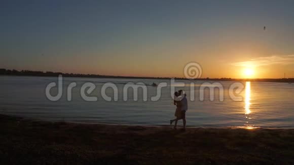 一对情侣在日落热带背景下的剪影视频的预览图