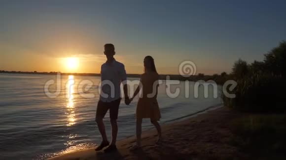一对情侣在日落热带背景下的剪影视频的预览图