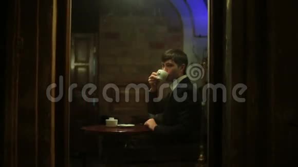 年轻人在咖啡馆里喝咖啡秋日雨雨视频的预览图