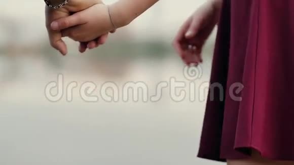 情侣手的特写恋爱中的一对情侣手牵着手站着离开摄像机慢节奏视频的预览图