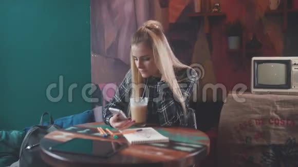 可爱的女孩独自坐在咖啡馆里在社交网络中交流视频的预览图