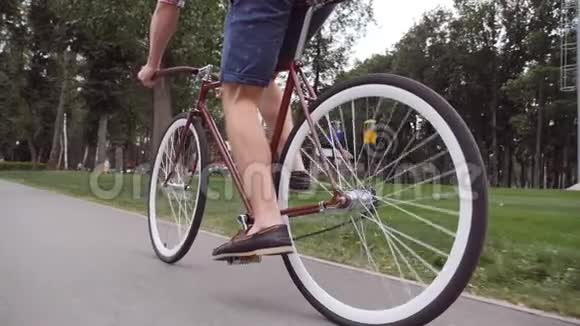 不可辨认的年轻人骑着一辆老式自行车运动男在公园骑自行车健康的积极生活方式低视野视频的预览图