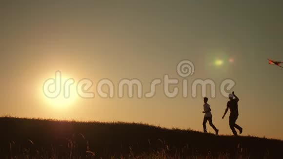 一个幸福的家庭一家人在夏天的夕阳下发射风筝飞向天空视频的预览图