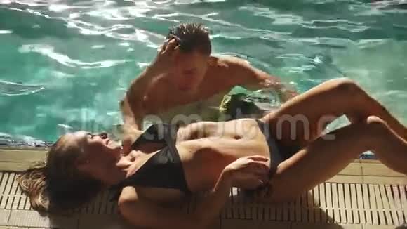 情侣在豪华亚洲酒店的游泳池里游泳玩得开心说话男人看着女孩很兴奋金发美女视频的预览图