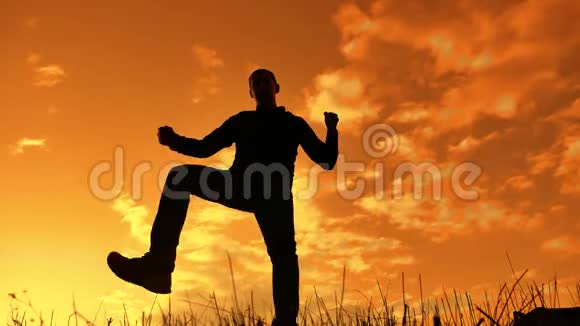 一个男人在日落时滑稽地跳舞的剪影有趣的人笑生活方式跳舞娱乐视频的预览图