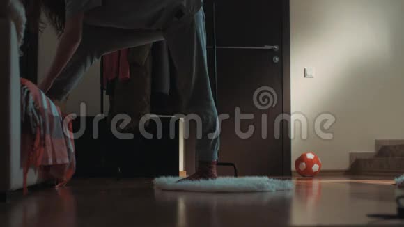 客厅里的年轻灵活的女人在地毯上滑倒不小心弄裂视频的预览图