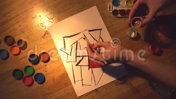 年轻女孩艺术家的俯视图用木地板上的水彩颜料创作插图视频的预览图