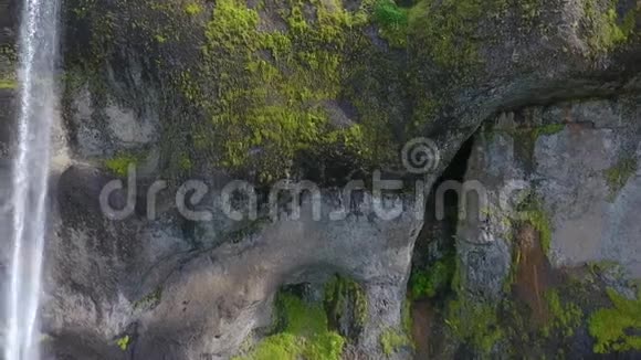 一股水流沿着山上有洞穴的石壁落下安德列夫视频的预览图