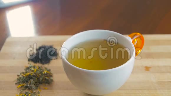 女人用勺子把糖加入茶杯里搅拌视频的预览图