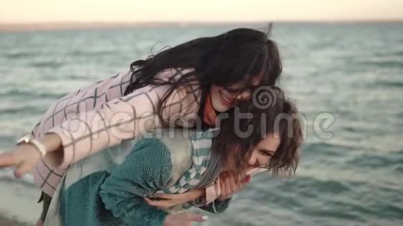 两个年轻迷人的女孩玩得开心拥抱最好的朋友花时间在户外水边肖像视频的预览图