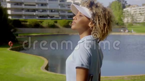 女高尔夫球手走在湖边视频的预览图
