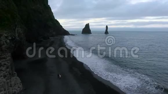 人们在海滩上走在岩石山附近安德列夫视频的预览图