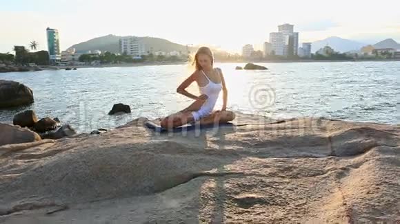 落基海滩腰部瑜伽脚的金发女郎视频的预览图