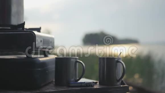 两杯热茶在一个气体旅游盘的背景下一个湖阳光明媚带着运动视频的预览图