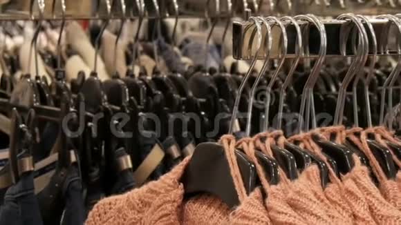 服装店购物中心衣架上挂着大量不同颜色的新款保暖时尚毛衣视频的预览图