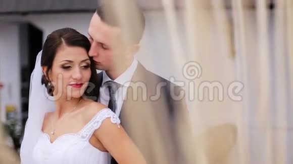 美丽的新娘感到受到保护并真的很高兴丈夫的手并拥抱他在他们的婚礼当天视频的预览图