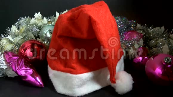 这只手从圣诞老人的帽子下面拿出一件价值一百美元圣诞礼物视频的预览图