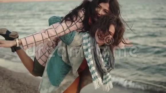 两个年轻迷人的女孩玩得开心拥抱最好的朋友花时间在户外水边肖像视频的预览图