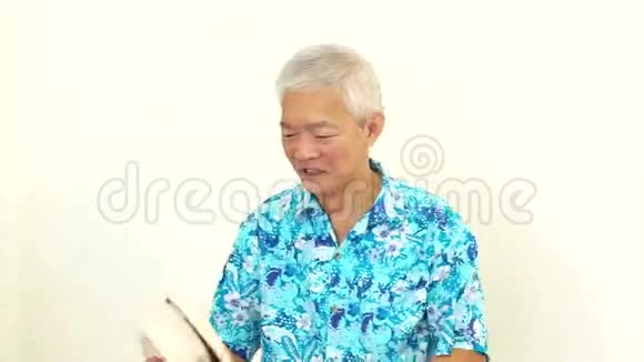 视频亚洲老人穿着蓝色夏威夷衬衫和帽子准备好去度假了视频的预览图