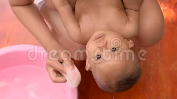 可爱的亚洲小宝宝和妈妈一起在户外洗澡视频的预览图