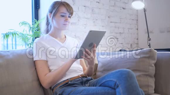 卧室沙发床上女子平板电脑在线视频聊天视频的预览图