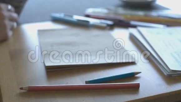 带戒指的女性用彩色铅笔在桌子上用杯子和茶托画视频的预览图