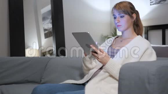 女人在平板电脑上上网坐在沙发上视频的预览图