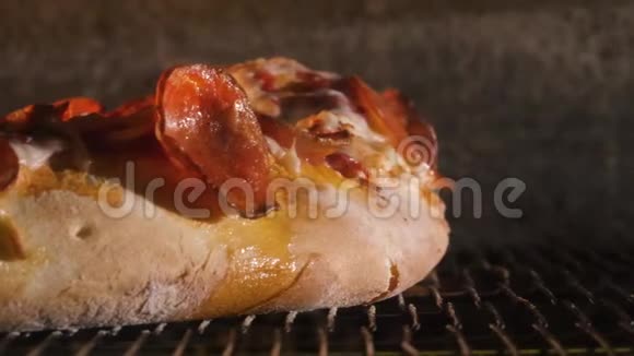 披萨在烤箱里用辣椒和奶酪做特写框架传统的比萨饼在烤箱里煮视频的预览图