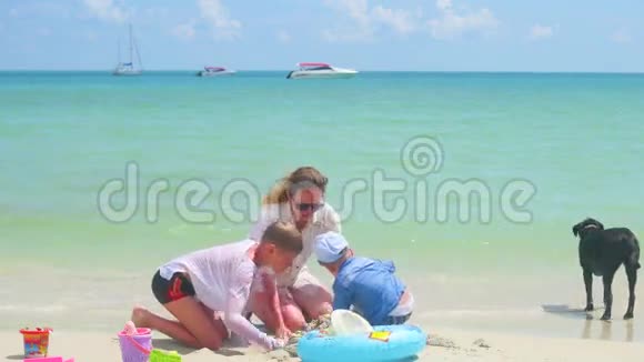 快乐的家庭有孩子和狗在沙滩上玩玩具热带岛屿天气炎热视频的预览图
