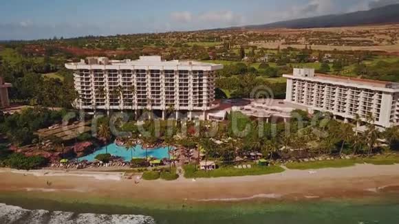 夏威夷毛伊岛海岸附近拥有美丽游泳池和异国情调的舒适现代度假胜地凯悦的空中镜头视频的预览图