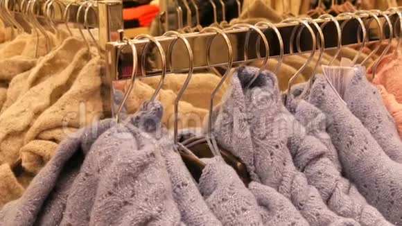 服装店购物中心衣架上挂着大量不同颜色的新款保暖时尚毛衣视频的预览图